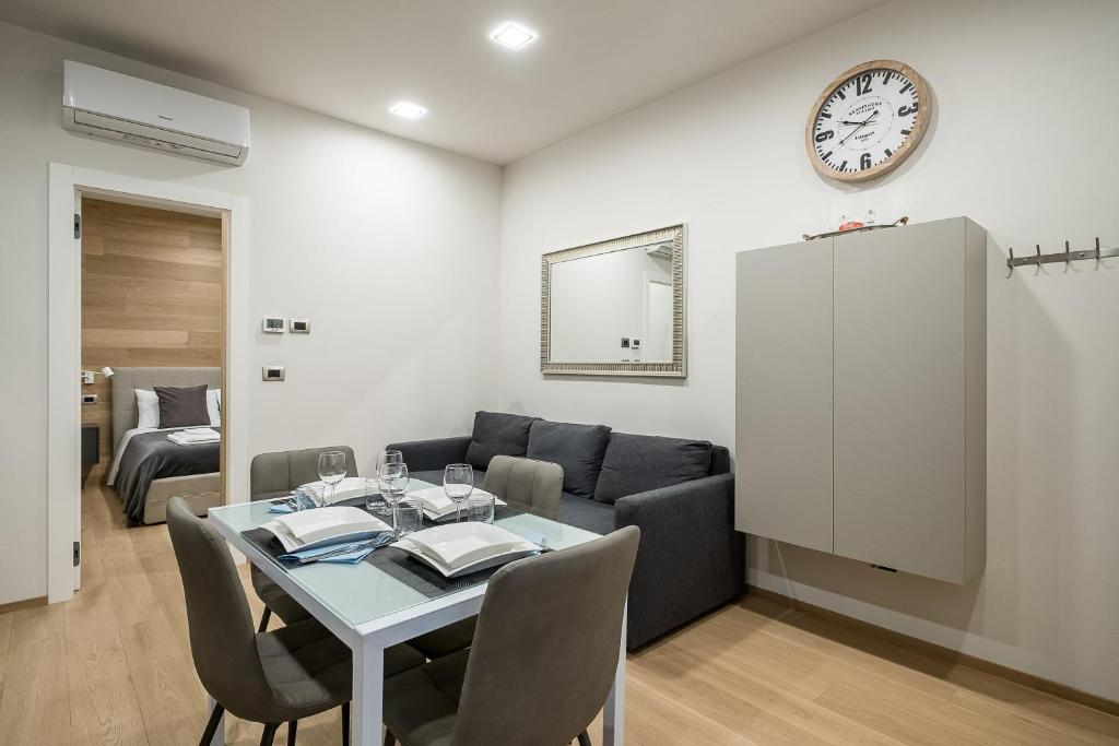 een woonkamer met een tafel, een bank en een klok bij Fragole Suite in Bologna