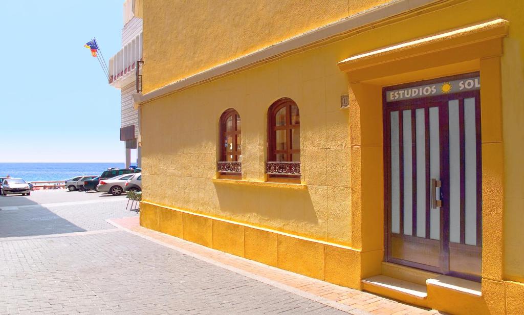un edificio amarillo al lado de una calle en Estudios RH Sol en Benidorm