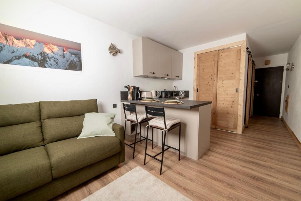 a living room with a couch and a kitchen with a table at Charmant Studio tout confort au Brévent-Chamonix in Chamonix-Mont-Blanc