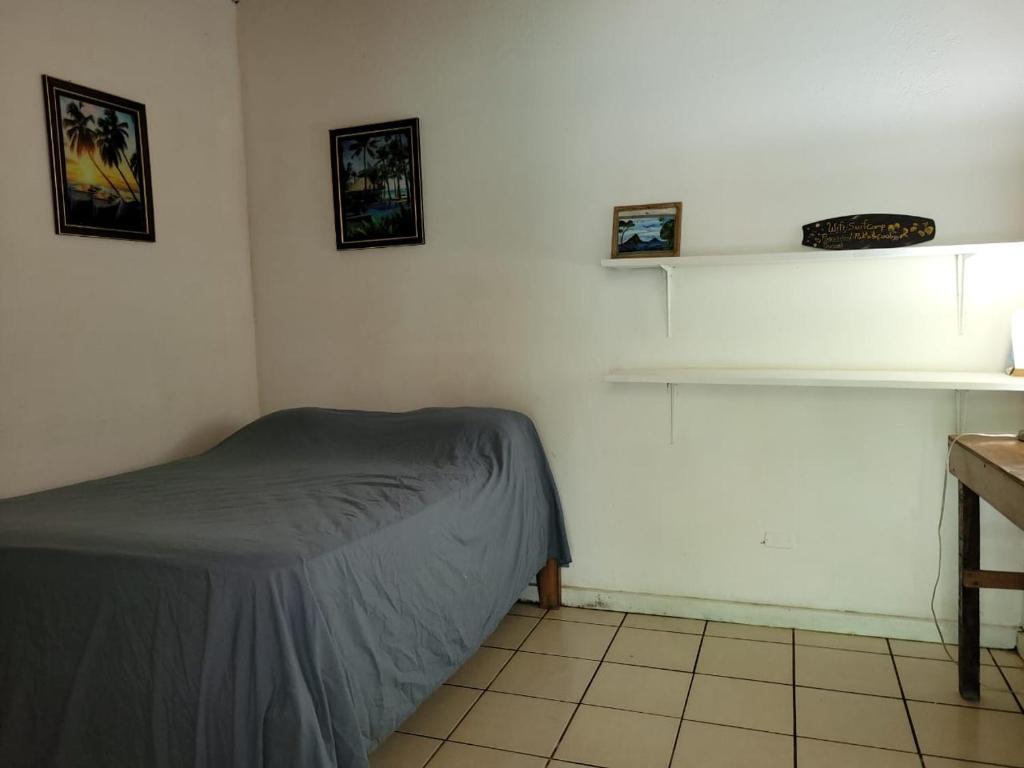 a bedroom with a bed and a shelf on the wall at J Bay : Burnt Toast Surfcamp in Nosara