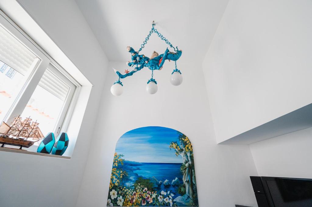a chandelier hanging from a wall with a painting at La Bella Annacapri in Anacapri