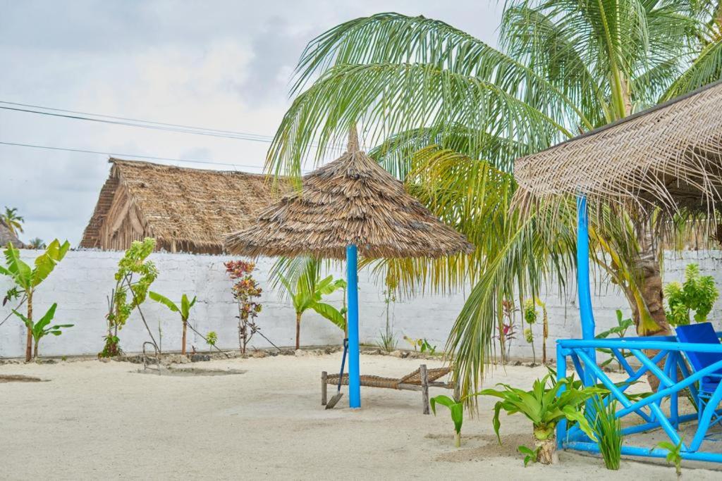 einen Strand mit Liegestühlen und Sonnenschirmen auf dem Sand in der Unterkunft Beach House Paje in Paje