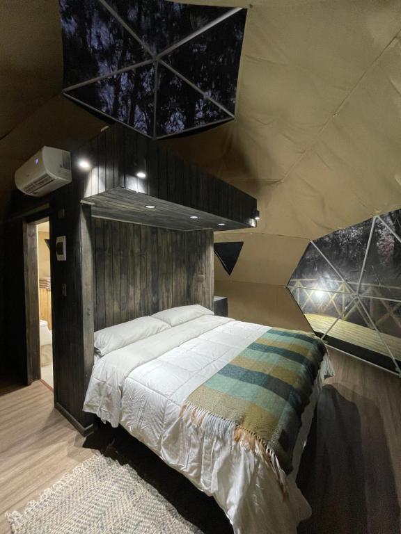 1 dormitorio con 1 cama grande en una tienda de campaña en Domos Paseo Nativo, en Chillán