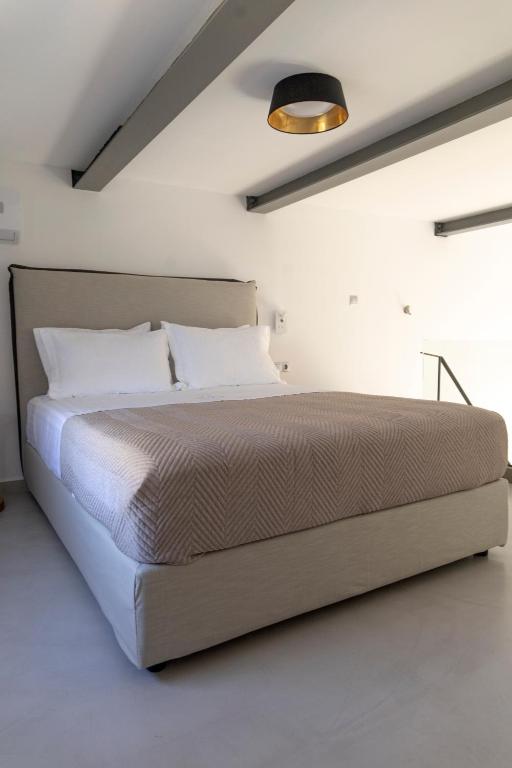 A bed or beds in a room at SKYROS BLUE SUITES