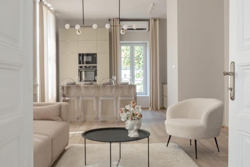 a living room with a couch and a table and a chair at Central Park Apartments in Bjelovar