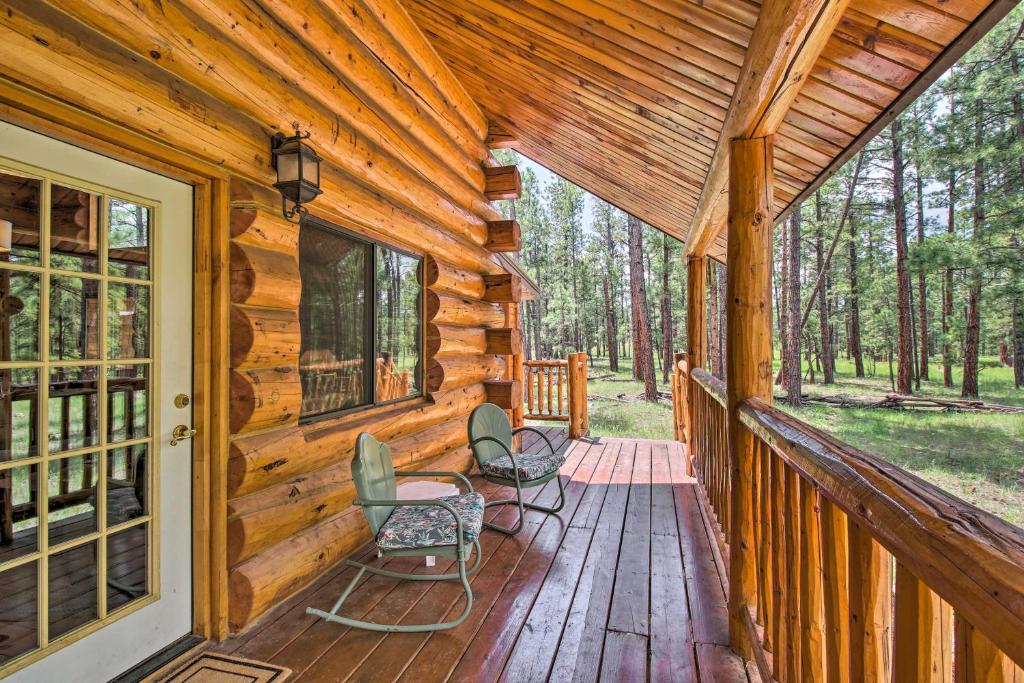 a porch of a wooden cabin with chairs on it at Tranquil Mountain Cabin with Game Room and Fireplace! in Greer