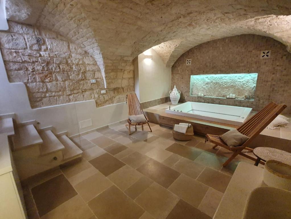 una grande camera con vasca da bagno in un muro di pietra di Alba Luxury Suite a Ostuni