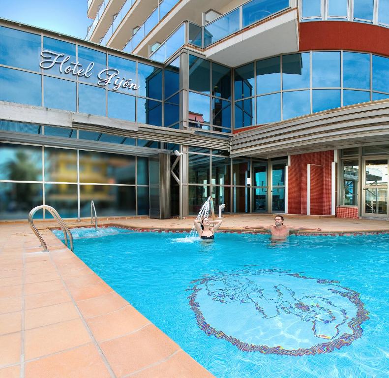 a swimming pool in front of a building at Hotel RH Gijón & Spa in Gandía