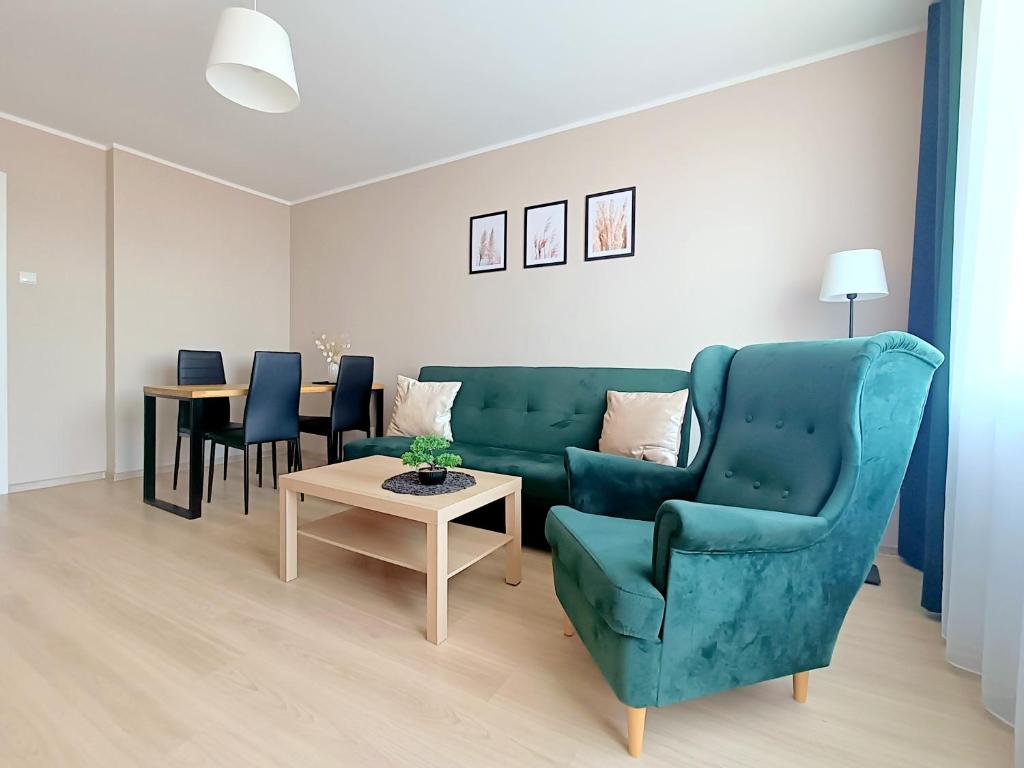 un soggiorno con divano, sedie e tavolo di Meraki Apartments a Danzica