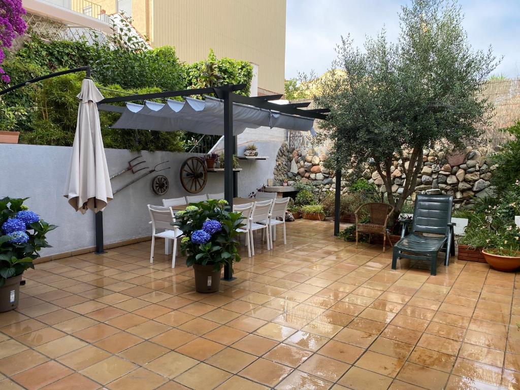 a patio with an umbrella and chairs and tables at Apartamentos Playa in Badalona