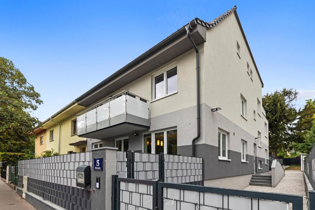 a house with a fence in front of it at Wienerberg-Apartments in Vienna