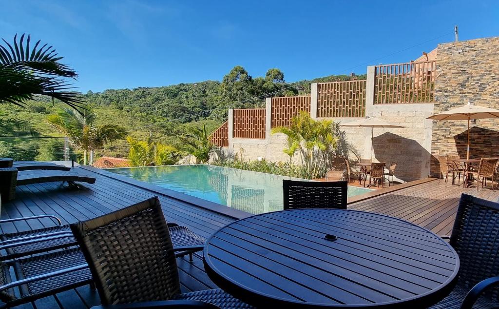 een tafel en stoelen op een terras met een zwembad bij Valle Paradiso in Praia do Rosa