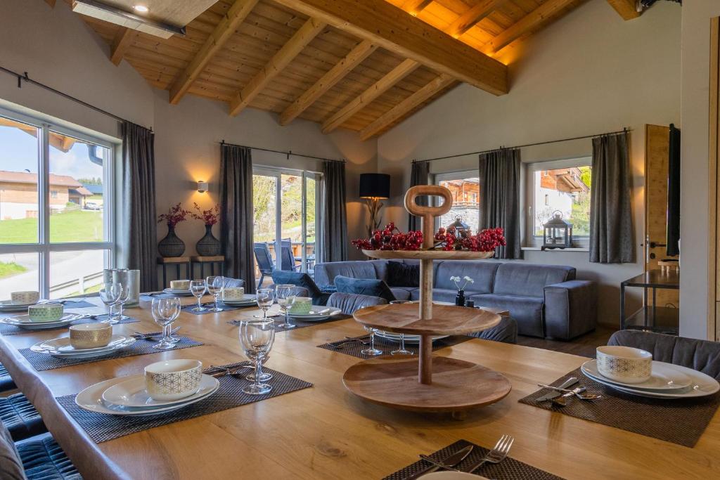 ein Esszimmer mit einem Tisch mit Brille und einem Sofa in der Unterkunft Haus am Bach in Kaprun