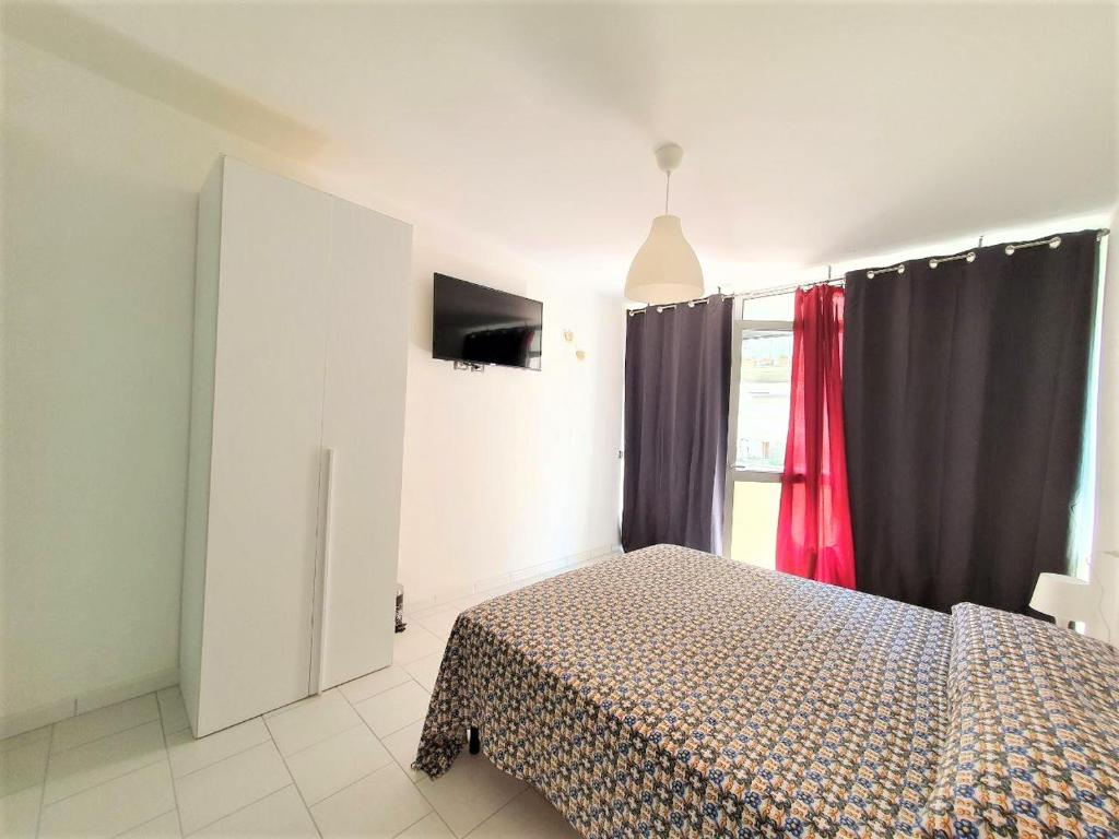 Schlafzimmer mit einem Bett und einem Fenster mit Vorhängen in der Unterkunft Affittacamere Casa Cynda in Follonica