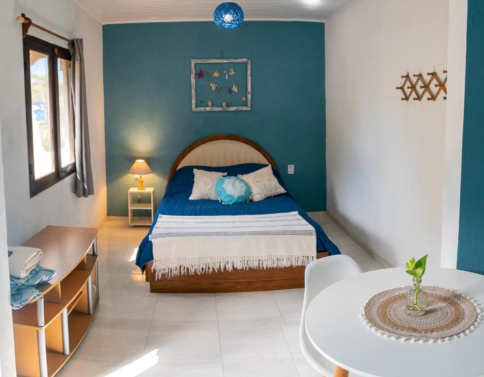 1 dormitorio con cama y pared azul en Cabañas Virazon Aguas Dulces, en Aguas Dulces
