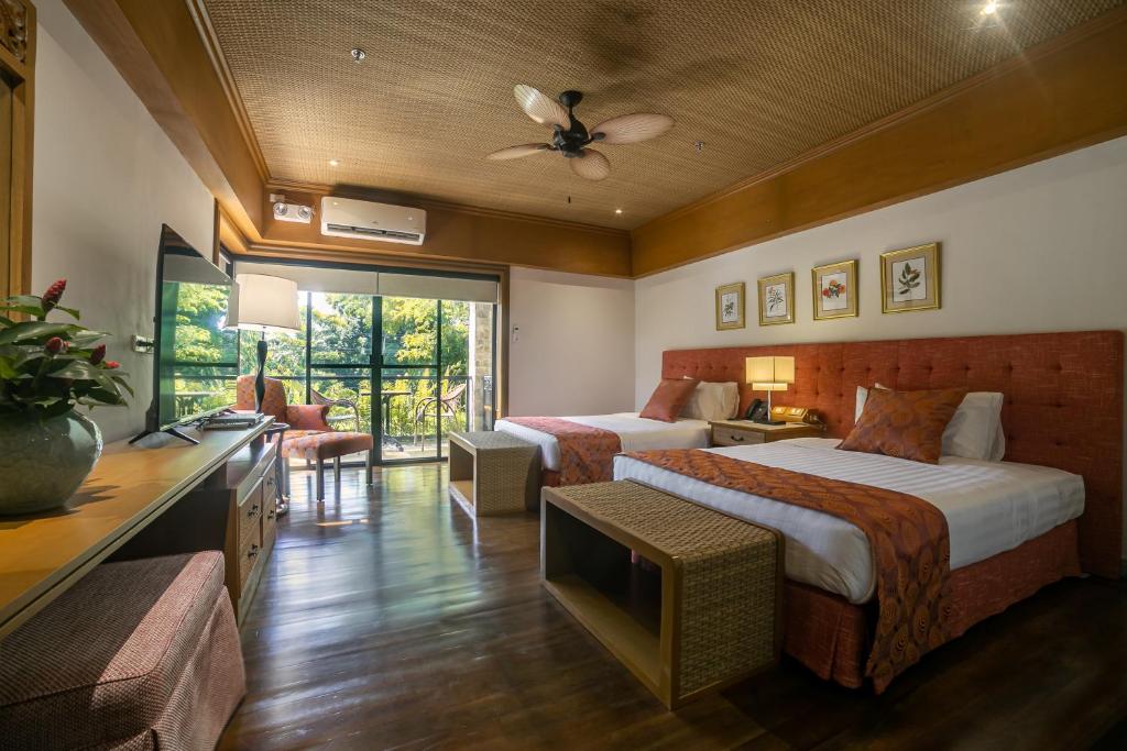 a hotel room with two beds and a television at Istorya Forest Garden Resort 