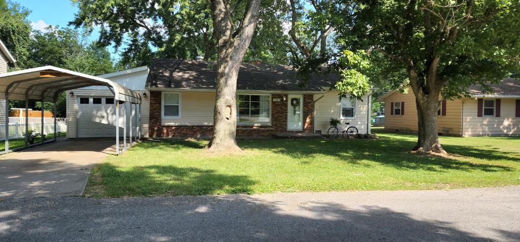 uma casa com garagem e duas árvores no quintal em Our Murphy Home in Murphysboro IL em Murphysboro