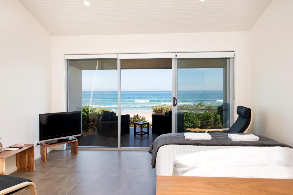 a bedroom with a bed and a view of the ocean at Seafarers Getaway in Apollo Bay