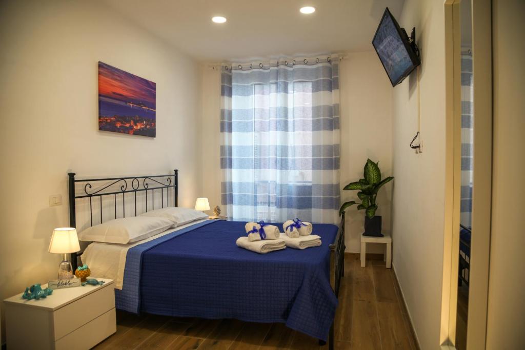 ein Schlafzimmer mit einem blauen Bett und Handtüchern darauf in der Unterkunft Filoblu appartamento Formia in Formia