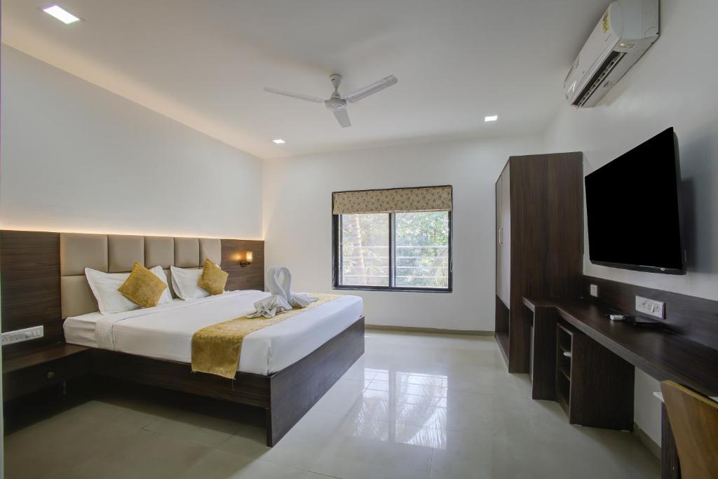 1 dormitorio con 1 cama grande y TV de pantalla plana en StayBird - AERITH STUDIOS, Exclusive Residences, Kharadi, en Pune