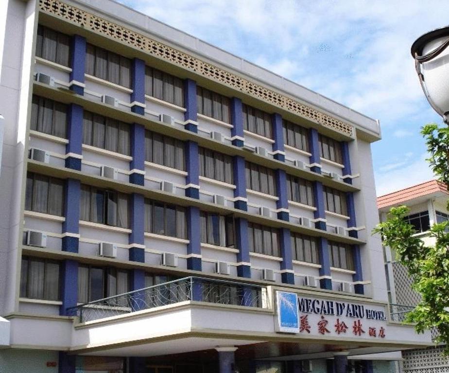 un gran edificio con un cartel delante en Megah D'aru Hotel, en Kota Kinabalu