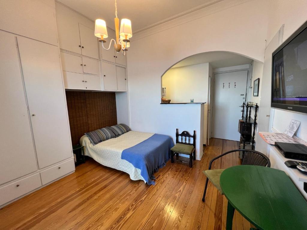 1 dormitorio con cama, escritorio y mesa en Frente a la Playa Pocitos!, en Montevideo