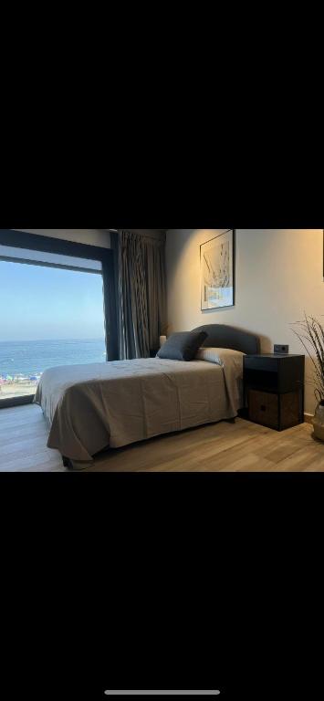 a bedroom with a large bed and a large window at Victoria loft in Castell de Ferro