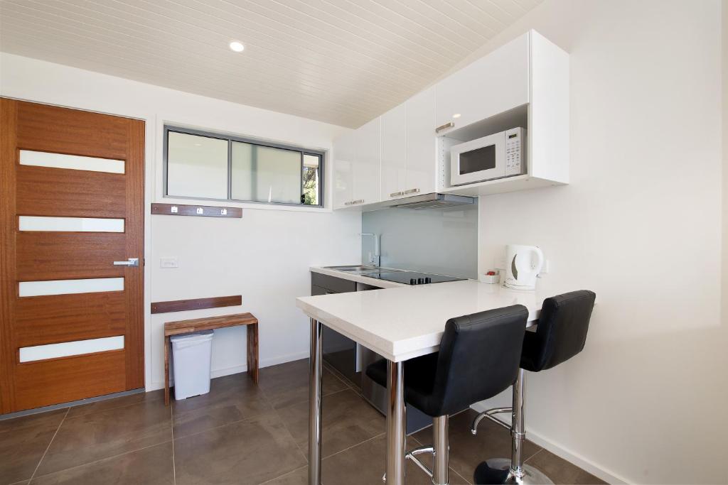 a kitchen with a table and two chairs and a microwave at Seafarers Getaway in Apollo Bay