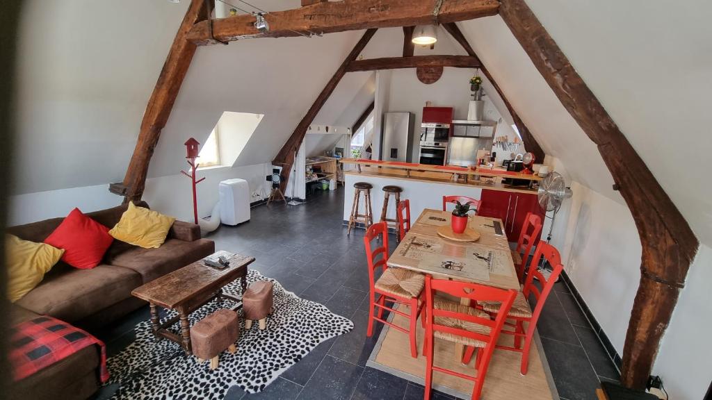 uma sala de estar com um sofá e uma mesa em Appartement familial avec balcon em Trosly-Breuil