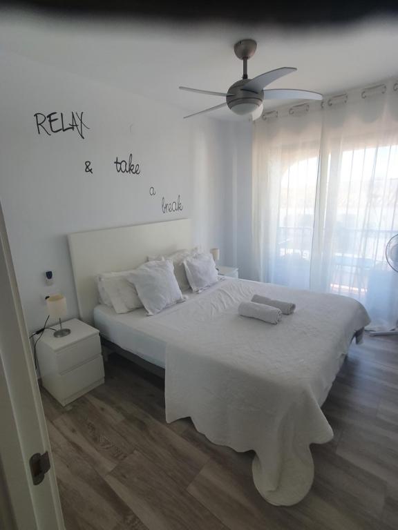 ミハスにあるYour place to relax in Mijas Costaの白いベッドルーム(ベッド1台、天井ファン付)