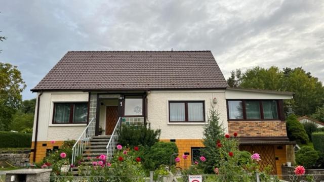 uma casa com telhado castanho e algumas flores em Pension Zum Taucher em Gosen