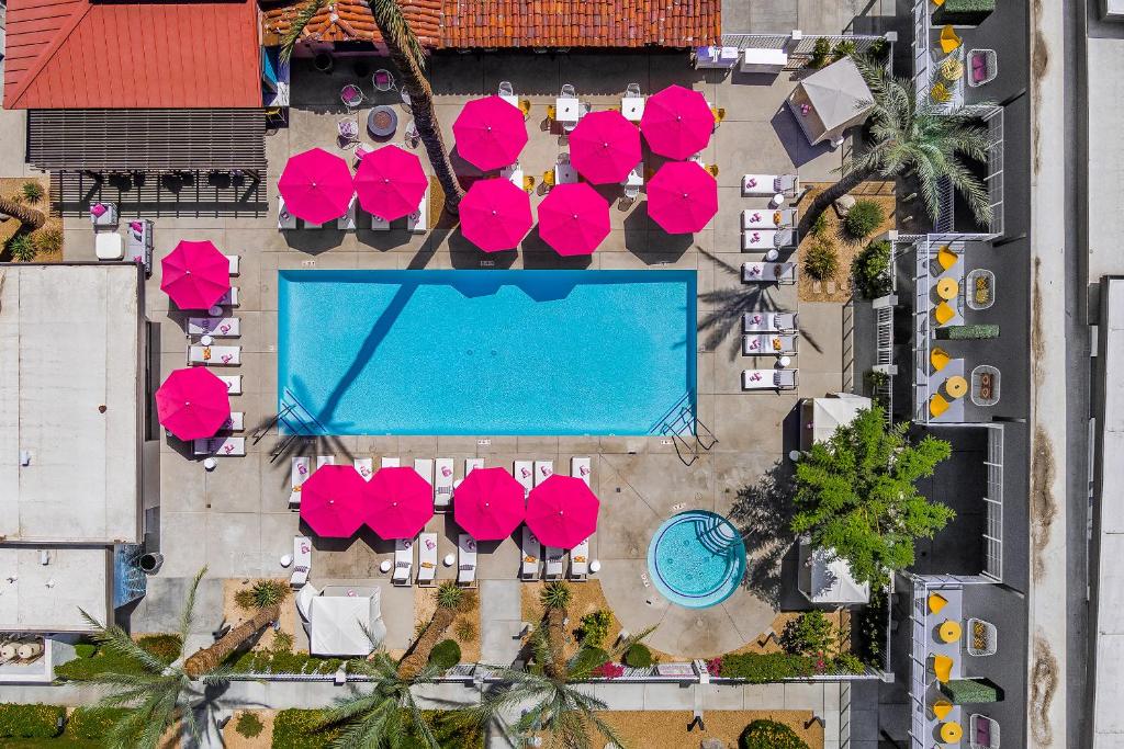 an overhead view of a pool with pink tables and chairs at The Paloma Resort in Palm Springs