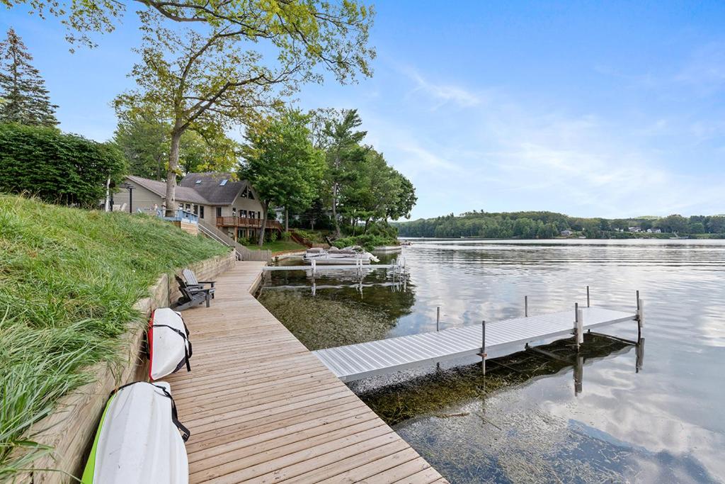 un molo in legno con una barca sull'acqua di Lakeside Getaway with Dock, Firepit, Grill a Newaygo