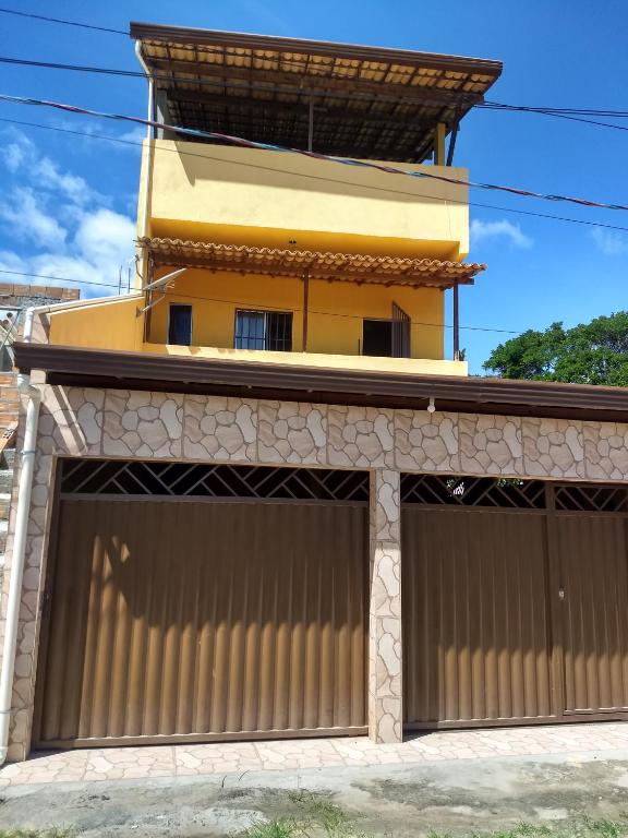 a building with two garage doors in front of it at Kitnets casa Amarela Imbassai in Imbassai