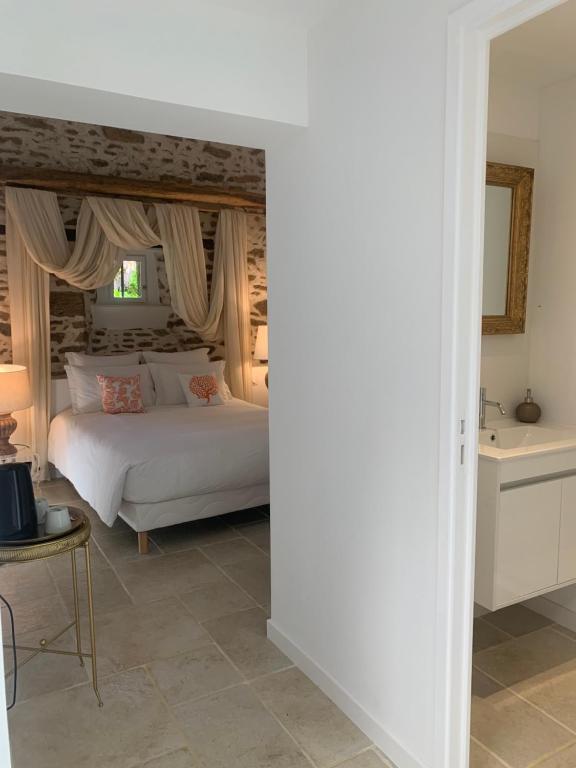 a bedroom with a white bed and a sink at LA MEFFRAIS 1741 in Dinan