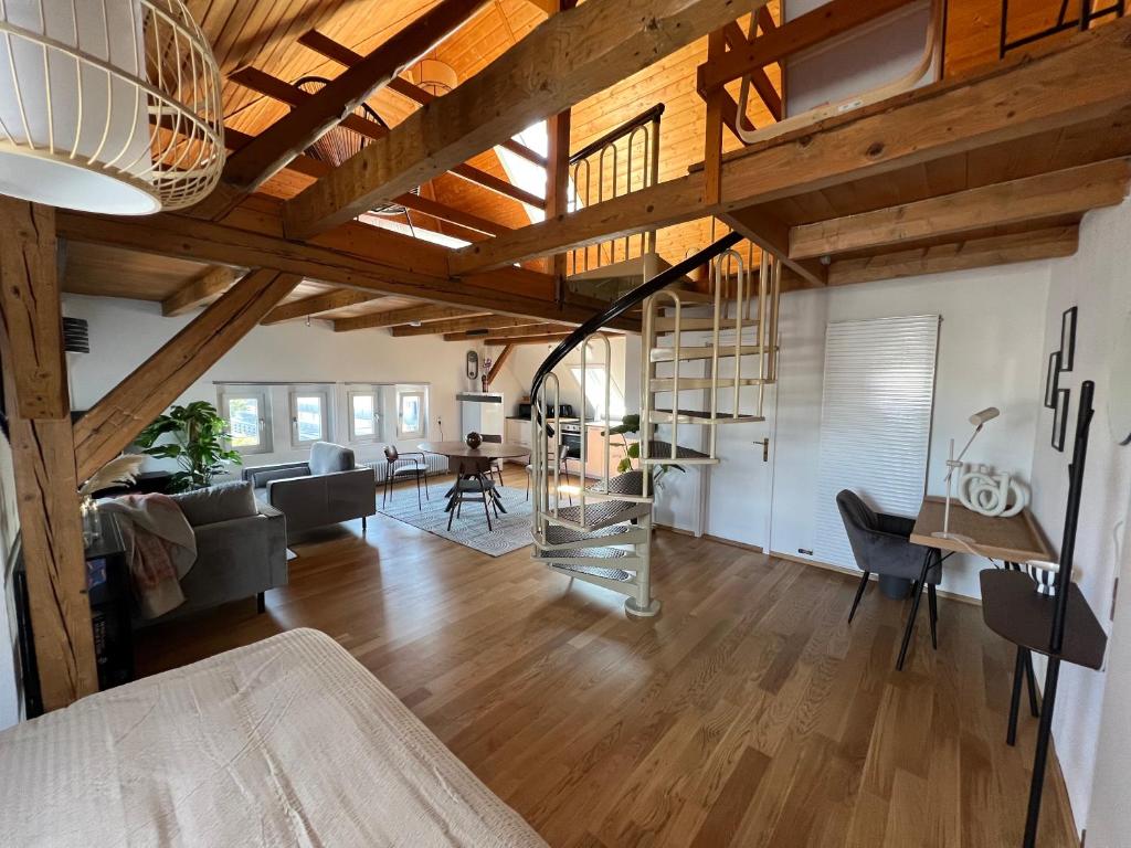 ein Wohnzimmer mit Holzdecken und ein Esszimmer in der Unterkunft Wohlfühl Loft - Seenähe, Netflix, Boxspringbett, Küche in Bregenz