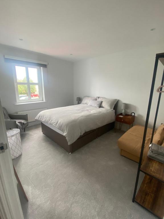 a white bedroom with a bed and a window at Harbour View Apartment in Killyleagh