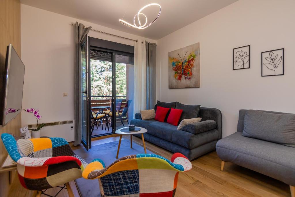 een woonkamer met een bank en een stoel bij Vila Pekovic Blue-Apartman PAMA in Zlatibor