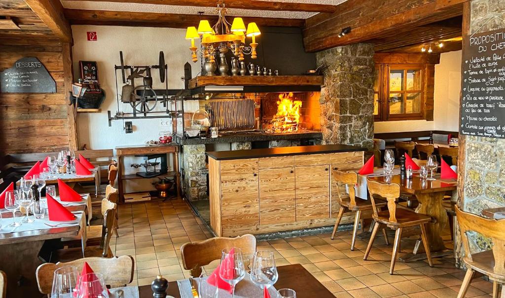a restaurant with tables and chairs and a fireplace at Hotel Les Chamois in Verbier