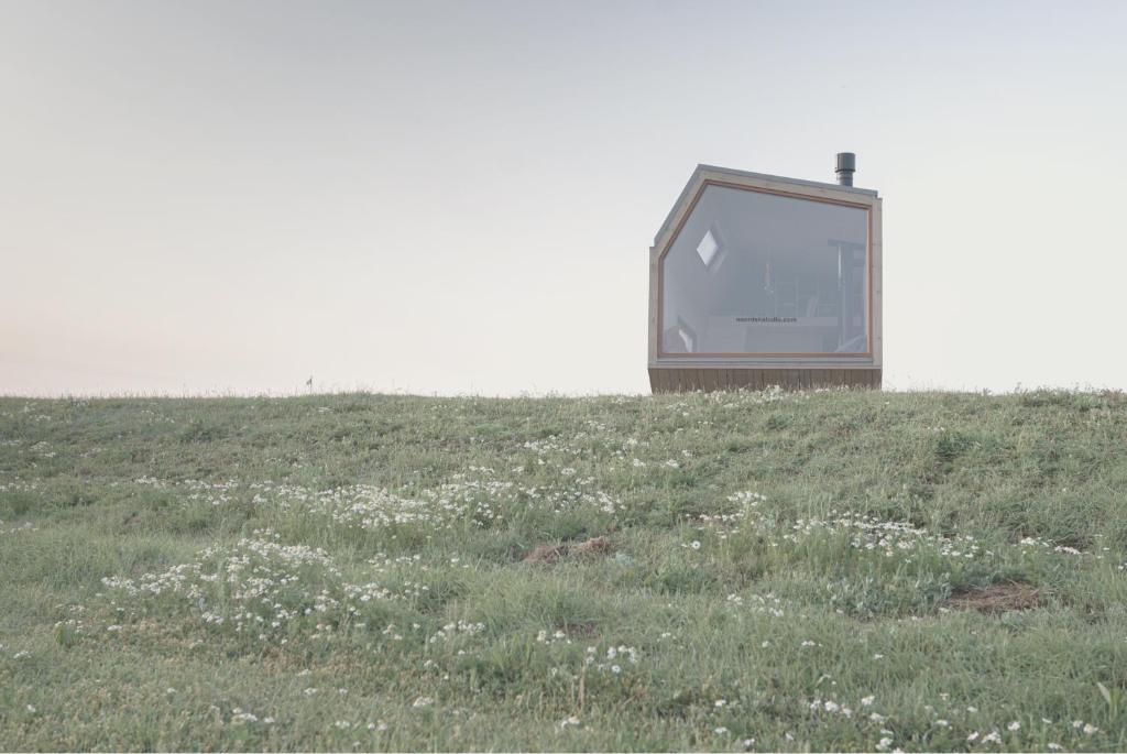 une télévision assise au-dessus d'un champ d'herbe dans l'établissement tinyzeit Urlaub im tiny house an der Flensburger Förde, à Steinberg