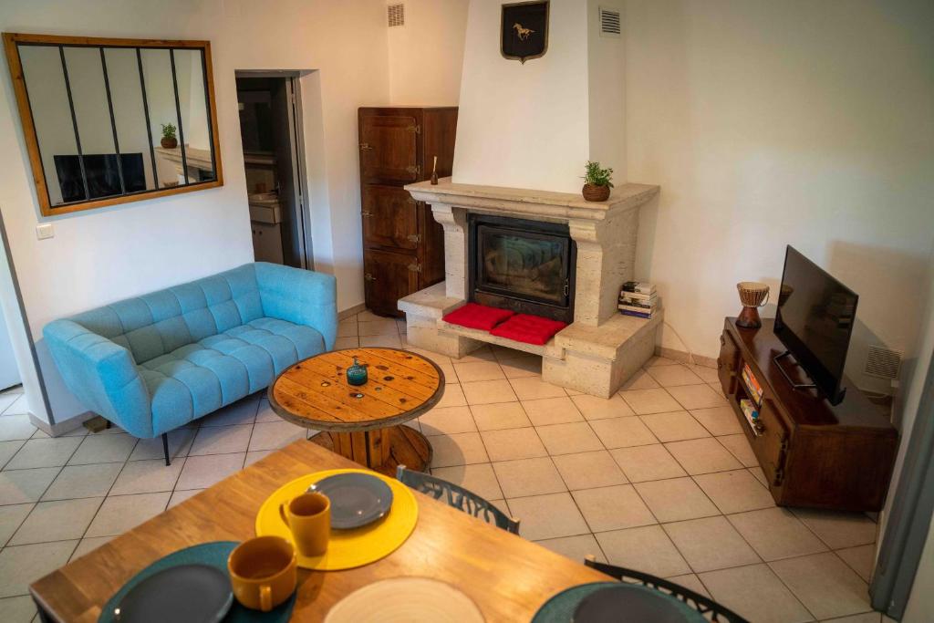 sala de estar con sofá azul y chimenea en Maison chaleureuse avec exterieur près de la ville, en Lafox