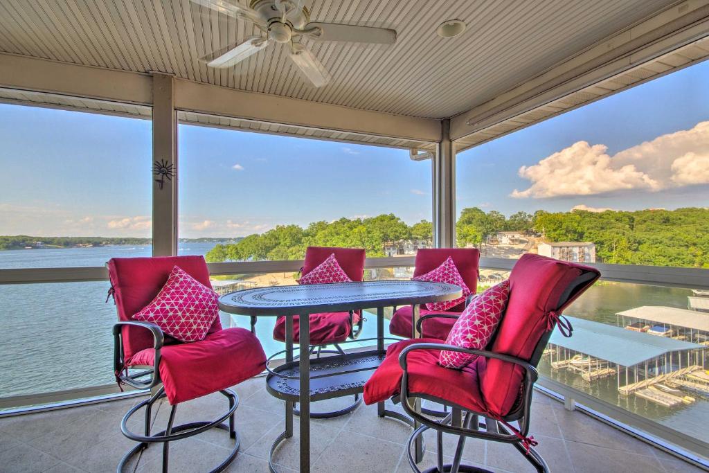 a table and chairs on a balcony with a view of the water at Top-Floor Lands End Corner Unit with Resort Perks! in Osage Beach
