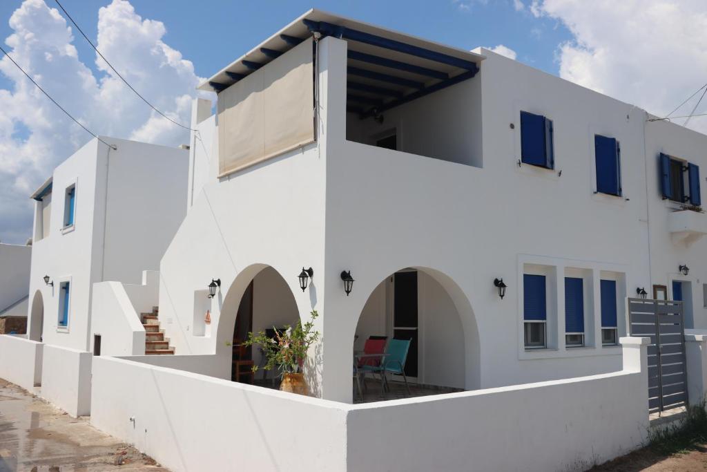 a white building with a large window on it at Avlemonas Guest House in Avlemonas