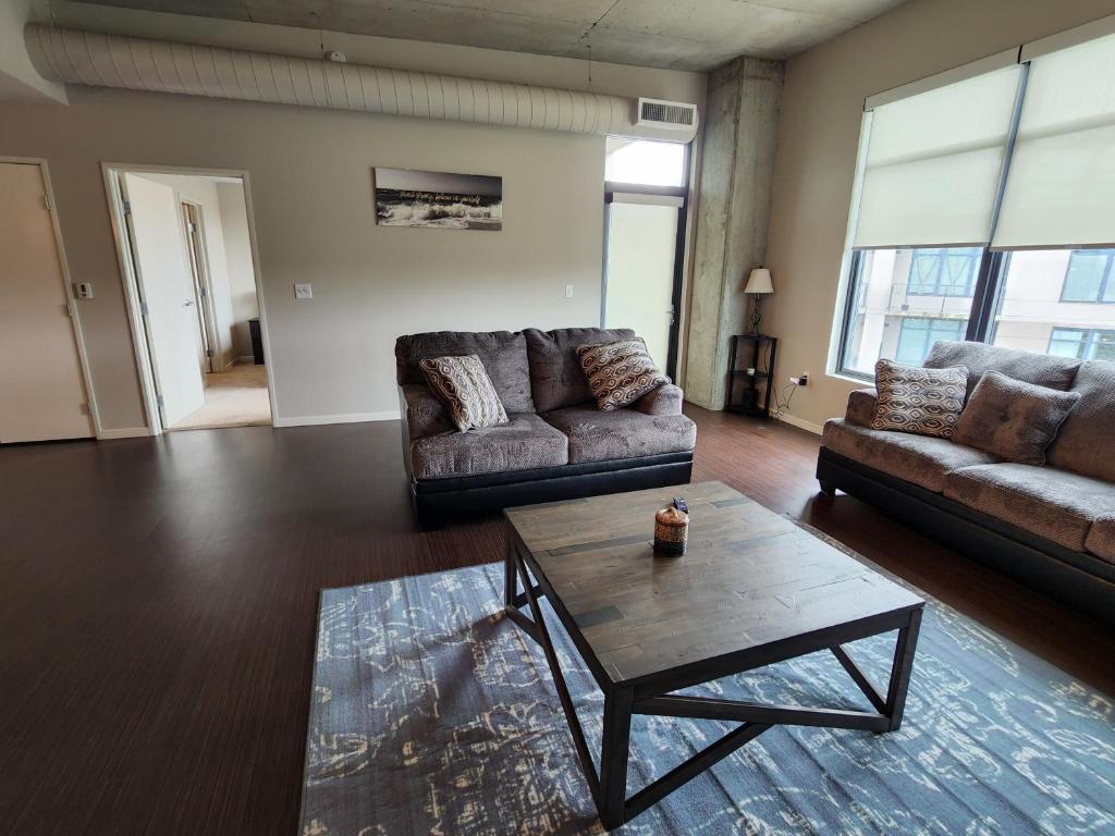 a living room with two couches and a coffee table at Penthouse Loft In The Flats in Cleveland