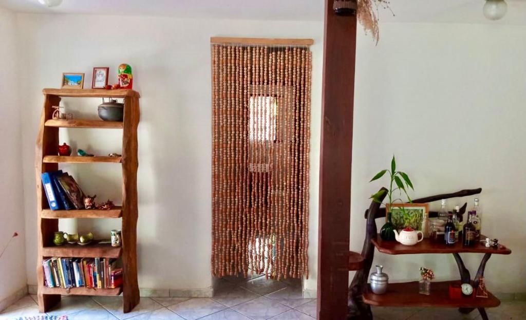 a room with a book shelf and a glass door at Aconchego da Raquel in Itaúnas