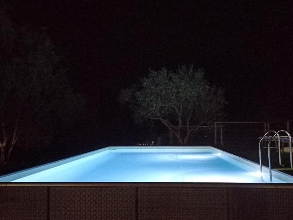 a swimming pool lit up at night at Casale Campecora in Barbarano Romano