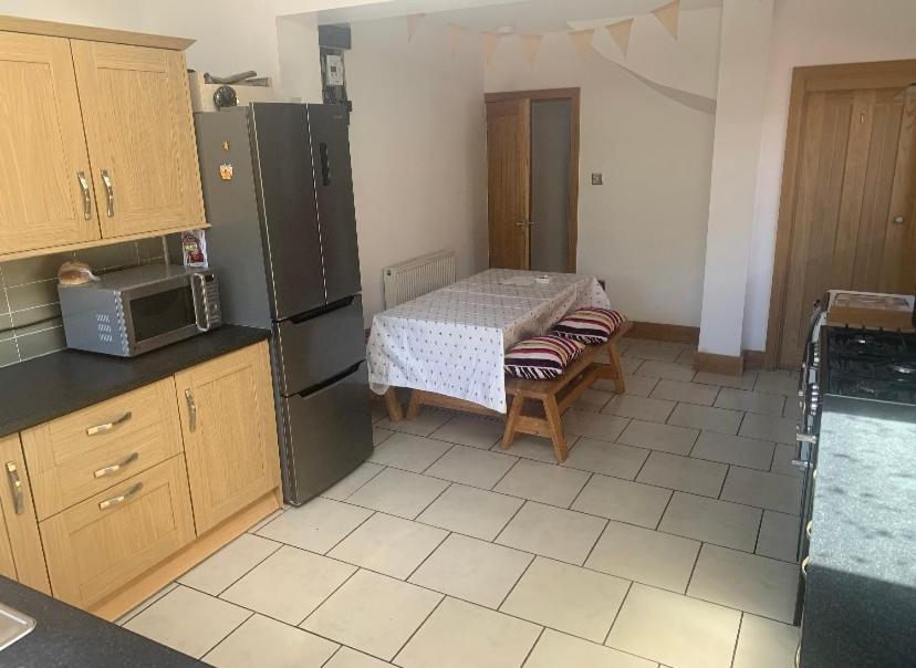 uma cozinha com uma pequena mesa e um micro-ondas em 4 Bedroom house with parking, Near Safari Park em Kidderminster