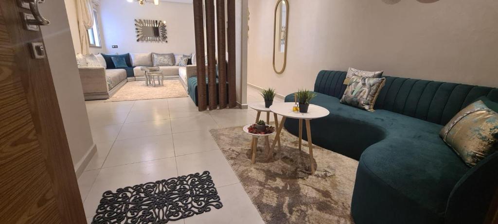 een woonkamer met een blauwe bank en een tafel bij Al Anouar Résidence in Kenitra