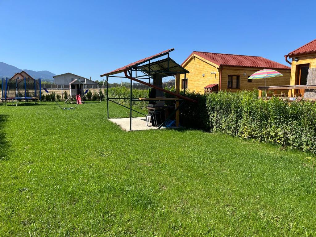 einen Park mit einem Schlagkäfig im Gras in der Unterkunft Casute la munte in Râșnov
