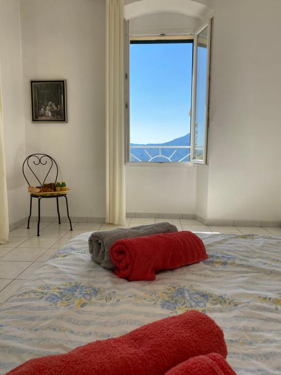 un grand lit dans une chambre avec une fenêtre dans l'établissement Casa Eugénie l'appartement de tante Madeleine vue sur les montagnes, à Venaco